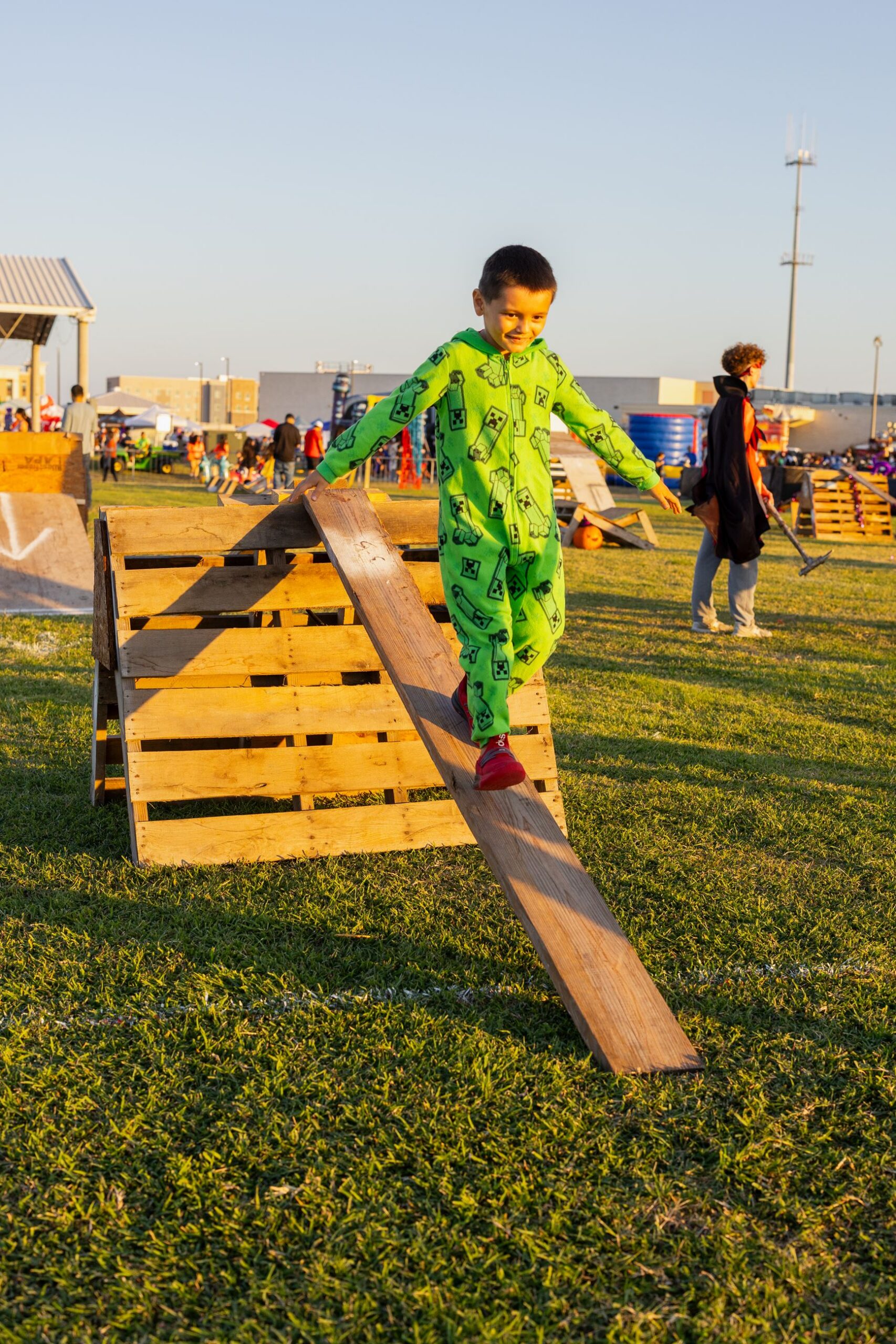 A child in costume crossing the wooden obstacle course