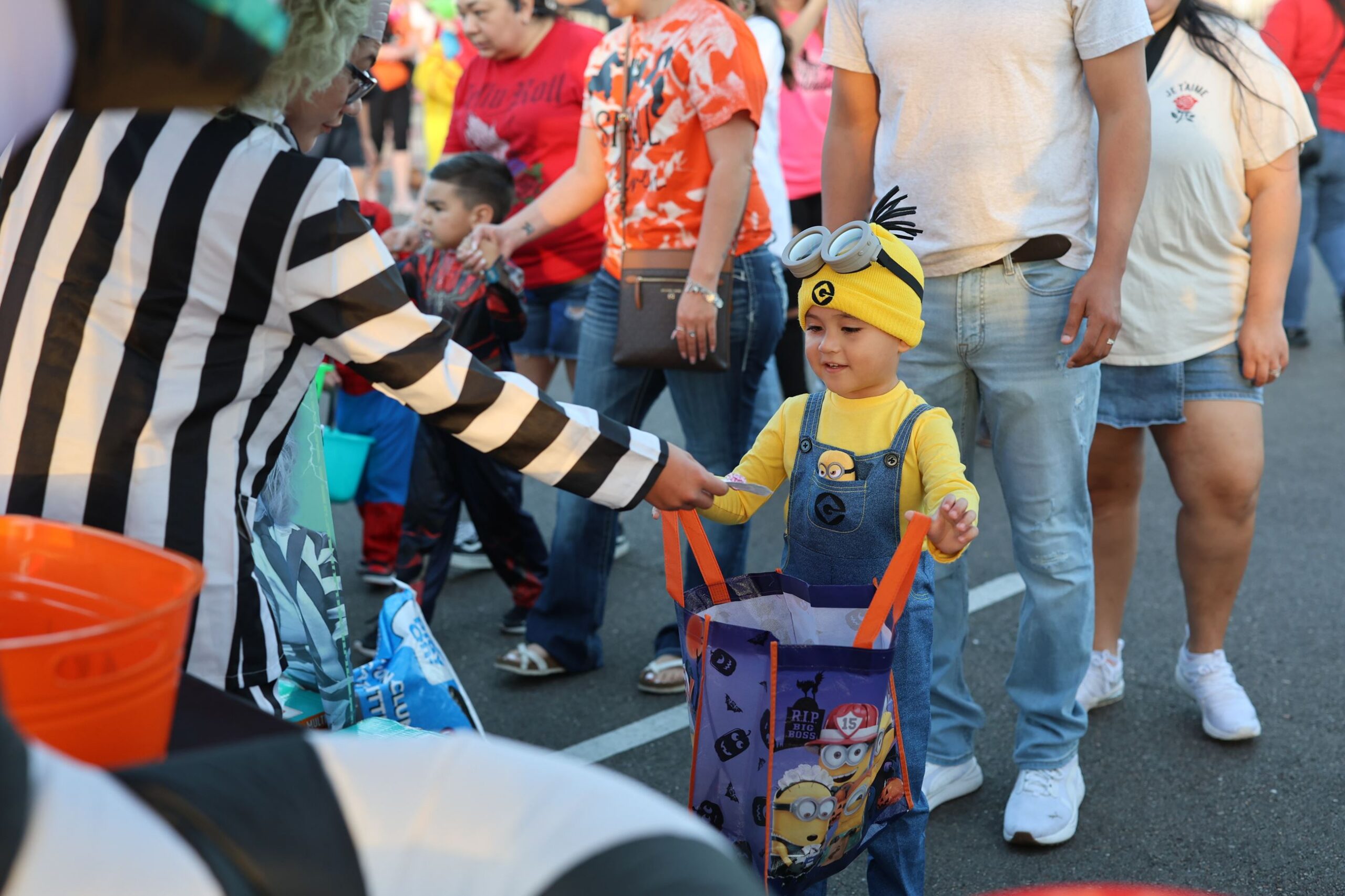 A child dressed as a minion trick-or-treating on the trail