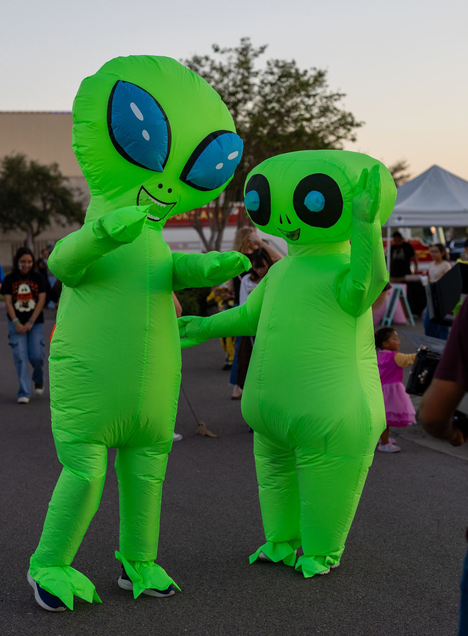 Two people in inflatable green alien costumes